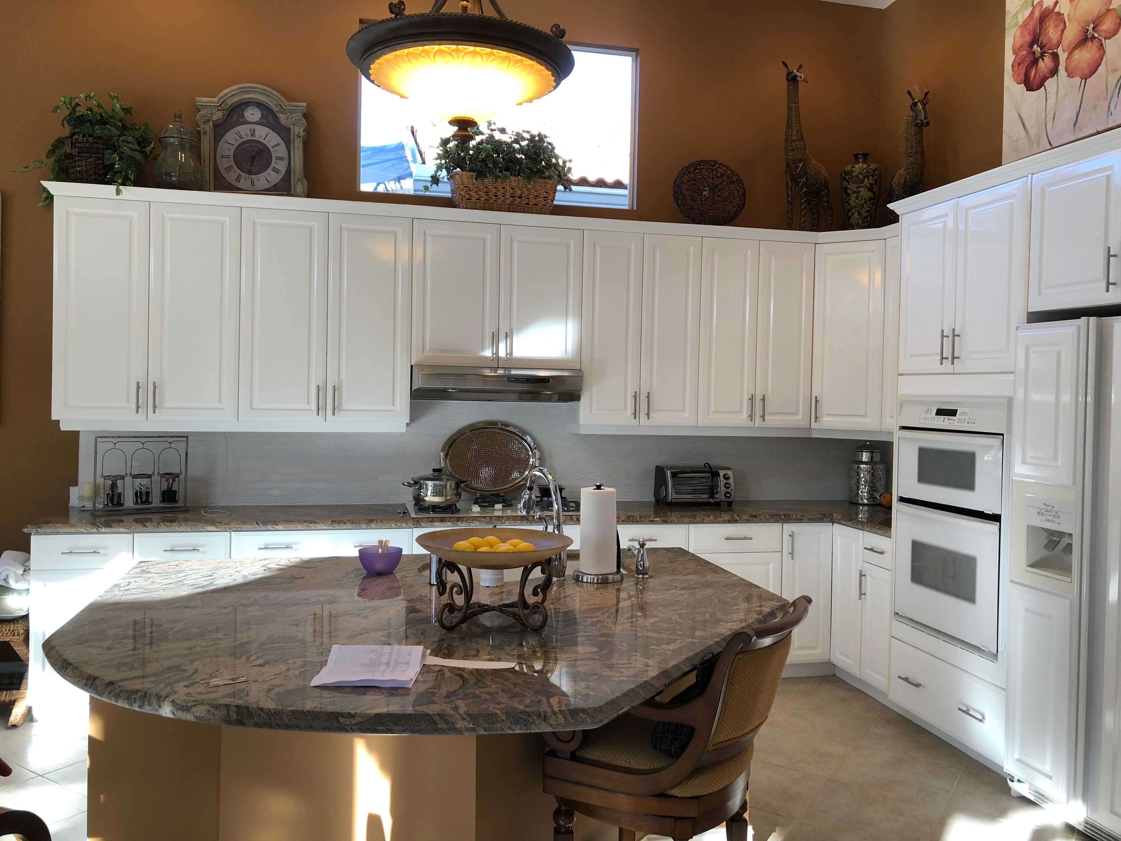 Kitchen with white cabinetry and granite island