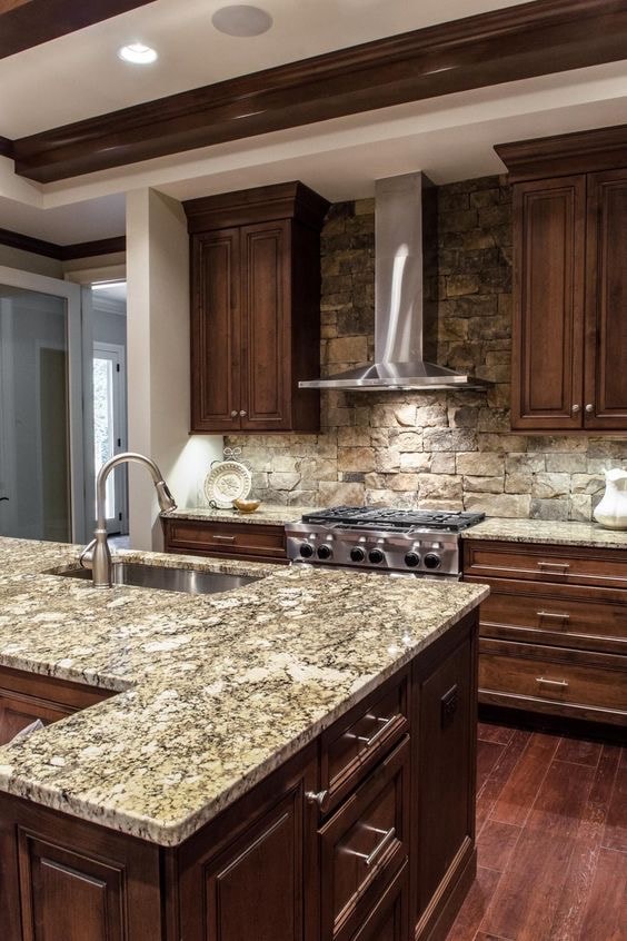 Kitchen with dark wood cabinetry and stone backsplash