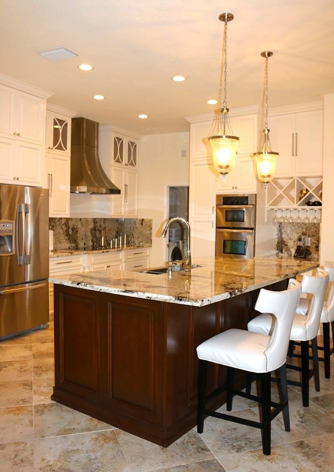 White kitchen with pendant lights and granite island