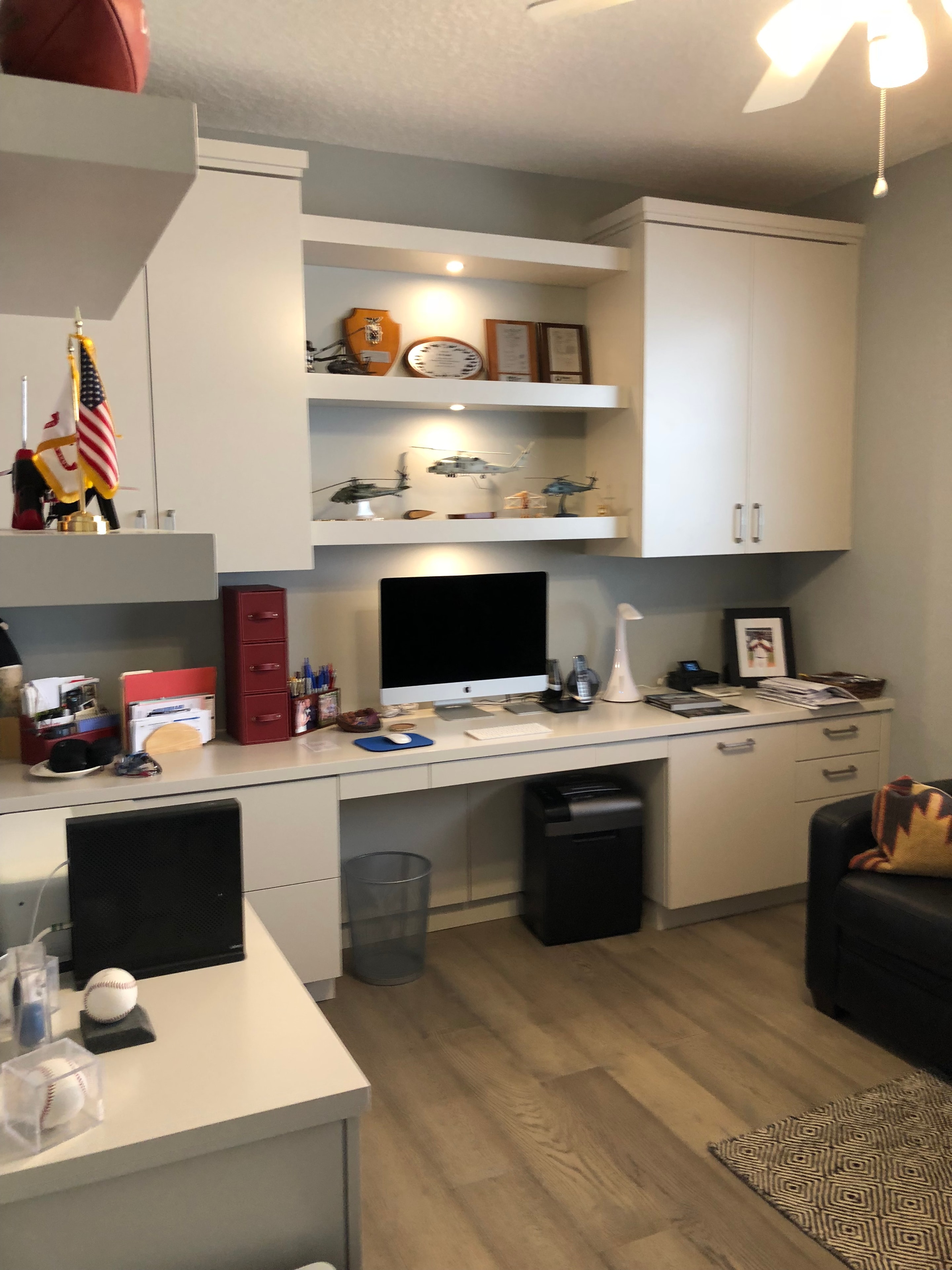 Home office with built-in white cabinetry and TV wall